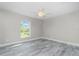 This bedroom features modern gray floors, white trim, a ceiling fan, and a window at 8270 Cook Ct, Port Charlotte, FL 33981