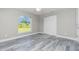 This bedroom features modern gray floors, white trim, a ceiling fan, a window and closet with doors at 8270 Cook Ct, Port Charlotte, FL 33981
