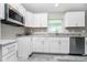 Modern kitchen featuring stainless steel appliances, granite countertops, white cabinets, and ample natural light at 8270 Cook Ct, Port Charlotte, FL 33981
