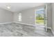 Light-filled living room featuring gray plank floors, a ceiling fan, and views of the yard at 8270 Cook Ct, Port Charlotte, FL 33981