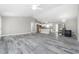 Open floor plan with gray wood-look tile, connecting the living room and kitchen for modern living at 8270 Cook Ct, Port Charlotte, FL 33981