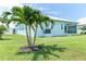 View of backyard, palm trees, exterior with screen patio, and lush green lawn at 8952 Scallop Way, Placida, FL 33946
