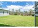 Large, well-maintained backyard featuring lush green grass and a backdrop of mature trees at 8952 Scallop Way, Placida, FL 33946