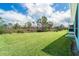Wide open backyard with lush lawn, leading to a wooded area, offering privacy and space at 8952 Scallop Way, Placida, FL 33946