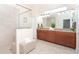 Bathroom featuring dual sinks, granite countertop, wood cabinets, large mirror, and glass enclosed shower at 8952 Scallop Way, Placida, FL 33946