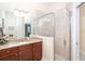 Bathroom featuring granite countertop, wood cabinets, glass enclosed shower, and decorative accents at 8952 Scallop Way, Placida, FL 33946