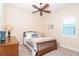 Bright bedroom with ceiling fan featuring a charming wood bed frame and coordinating dresser at 8952 Scallop Way, Placida, FL 33946