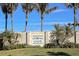 Entrance sign to a gated community with lush tropical landscaping including palm trees and a manicured lawn at 8952 Scallop Way, Placida, FL 33946
