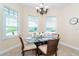 Bright dining area with modern chandelier, table setting, and natural light from white plantation shuttered windows at 8952 Scallop Way, Placida, FL 33946