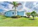 Side view of a charming home featuring well-manicured lawn and lush tropical landscaping at 8952 Scallop Way, Placida, FL 33946