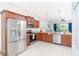Well-equipped kitchen with stainless steel appliances, wooden cabinetry, granite countertops, and tile flooring at 8952 Scallop Way, Placida, FL 33946