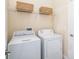Bright laundry room featuring white appliances, storage shelf, and neutral paint at 8952 Scallop Way, Placida, FL 33946