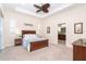 Bright main bedroom featuring tray ceiling, ceiling fan, en suite bathroom and decorative details at 8952 Scallop Way, Placida, FL 33946