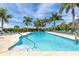 Community pool with palm trees, blue skies, and lounge chairs for relaxing at 8952 Scallop Way, Placida, FL 33946