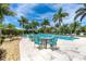 Community pool area featuring lush tropical landscaping and comfortable outdoor seating at 8952 Scallop Way, Placida, FL 33946