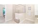 Bright bathroom featuring a glass-enclosed shower with white stone-look tile and a small bench at 8952 Scallop Way, Placida, FL 33946