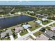 Aerial shot of homes surrounding a scenic lake, each with manicured lawns, pools, and tree-lined streets at 9064 Bantry Bay Blvd, Englewood, FL 34224