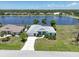 Aerial view of the charming property featuring a scenic pond view, driveway, and well-manicured landscaping at 9064 Bantry Bay Blvd, Englewood, FL 34224