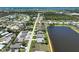 An aerial view of a serene lakefront neighborhood with well-maintained homes, lush landscaping, and mature palm trees at 9064 Bantry Bay Blvd, Englewood, FL 34224