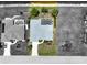 Aerial view of a home with a screened-in pool, lush landscaping, and a driveway leading to an attached garage at 9064 Bantry Bay Blvd, Englewood, FL 34224