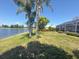 Backyard with direct access to the pond, surrounded by well-maintained landscaping and mature palm trees at 9064 Bantry Bay Blvd, Englewood, FL 34224