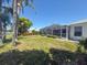 Landscaped backyard featuring a screened-in lanai with lush greenery, near the pond at 9064 Bantry Bay Blvd, Englewood, FL 34224