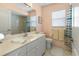 Bright bathroom featuring a white vanity, and bathtub with shower at 9064 Bantry Bay Blvd, Englewood, FL 34224
