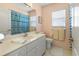 Bright bathroom featuring a white vanity, and bathtub with shower at 9064 Bantry Bay Blvd, Englewood, FL 34224