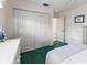 Bedroom features a large closet and an accenting green carpet at 9064 Bantry Bay Blvd, Englewood, FL 34224