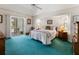 Bright bedroom featuring a sliding glass door, a ceiling fan, and teal-colored carpet at 9064 Bantry Bay Blvd, Englewood, FL 34224