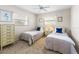 Bedroom features two twin beds, a ceiling fan, and matching dressers at 9064 Bantry Bay Blvd, Englewood, FL 34224