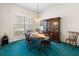 Traditional dining room with wood table, chairs, and a hutch, illuminated by a chandelier and natural light at 9064 Bantry Bay Blvd, Englewood, FL 34224