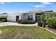 Charming home exterior featuring a manicured lawn, walkway, and lush landscaping leading to the front entrance at 9064 Bantry Bay Blvd, Englewood, FL 34224