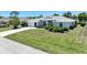 Inviting home featuring a well-manicured lawn, green shrubbery, and an attached two-car garage at 9064 Bantry Bay Blvd, Englewood, FL 34224