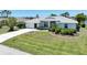 Beautiful home with a pristine lawn, manicured garden beds, and a concrete driveway leading to an attached garage at 9064 Bantry Bay Blvd, Englewood, FL 34224