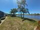 Tranquil lake view framed by swaying palms in this landscaped backyard create tropical paradise at 9064 Bantry Bay Blvd, Englewood, FL 34224