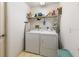 Functional laundry room with washer, dryer, and shelving for organized storage at 9064 Bantry Bay Blvd, Englewood, FL 34224