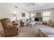 Comfortable living room featuring wicker furniture, a ceiling fan, and natural light from the windows at 9064 Bantry Bay Blvd, Englewood, FL 34224