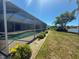 Sparkling pool with screened enclosure, complemented by lush landscaping, offers a serene outdoor experience at 9064 Bantry Bay Blvd, Englewood, FL 34224