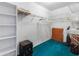 Spacious walk-in closet with built-in shelving and teal colored carpet at 9064 Bantry Bay Blvd, Englewood, FL 34224