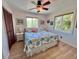 Bright bedroom with light wood floors, ceiling fan, and a beach-themed comforter on the comfortable bed at 9270 Little Gasparilla Is, Placida, FL 33946