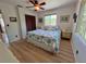 Sunlit bedroom boasts wood floors, ceiling fan, and beach-themed bedding creating a tranquil retreat at 9270 Little Gasparilla Is, Placida, FL 33946