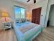 Sunny bedroom features a cozy bed, closet, and wood floors creating a welcoming and relaxing space at 9270 Little Gasparilla Is, Placida, FL 33946