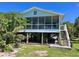 Inviting raised beach house with a screened porch, stairs, and a grill under it at 9270 Little Gasparilla Is, Placida, FL 33946