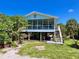 Inviting raised beach house with a screened porch, stairs, and a grill under it at 9270 Little Gasparilla Is, Placida, FL 33946