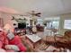 Open-concept living room flowing to the kitchen, featuring tiled floors and coastal decor at 9270 Little Gasparilla Is, Placida, FL 33946