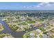 Scenic aerial view of homes nestled along winding canals in a vibrant waterfront community under a blue sky at 9532 Miami Cir, Port Charlotte, FL 33981