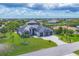 Wide aerial view of a single-Gathering home with dark roof, manicured lawn, and a three car garage at 9532 Miami Cir, Port Charlotte, FL 33981