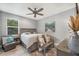 This bedroom has grey walls, light wood-look floors, and a decorative bench under an ocean-themed art piece at 9532 Miami Cir, Port Charlotte, FL 33981