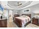 Primary bedroom featuring a tray ceiling, ceiling fan, a large bed, and ample dresser storage at 9532 Miami Cir, Port Charlotte, FL 33981